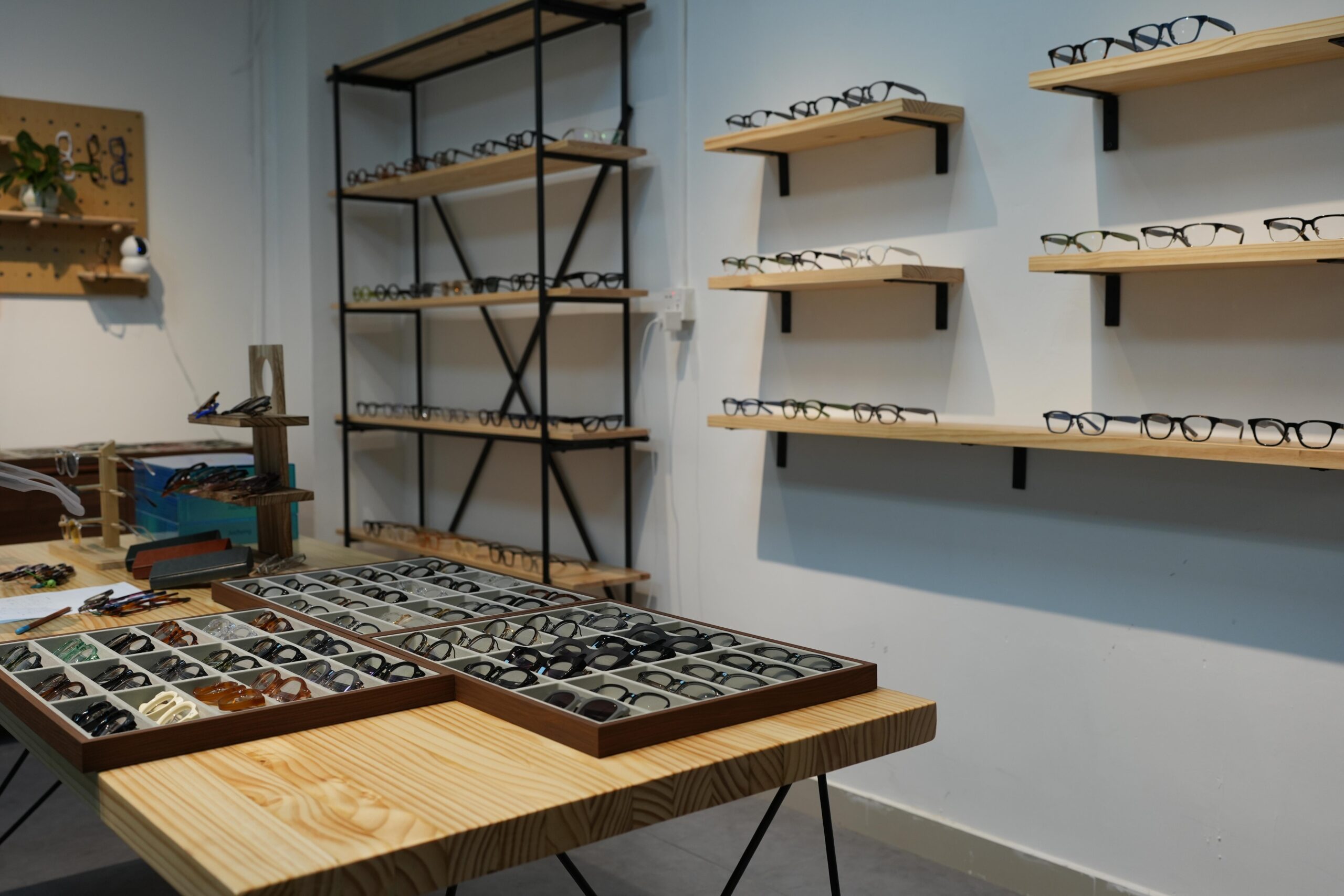 Eyewear frame samples displayed on shelves and a worktable