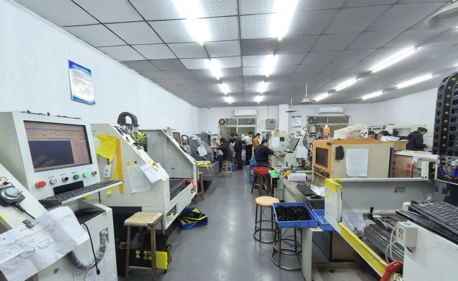 Eyewear production team reviewing work across a workshop floor